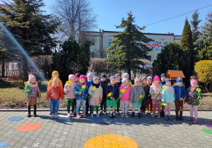 Ogród przedszkolny- Maluchy pozują do zdjęcia grupowego z okazji Pierwszego Dnia Wiosny.